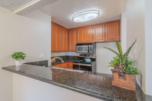 a kitchen with a granite counter top and at City View Apartments at Warner Center, California, 91367