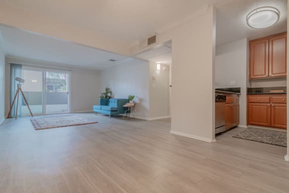 an open living room with a kitchen and a door to a balcony at City View Apartments at Warner Center, Woodland Hills California
