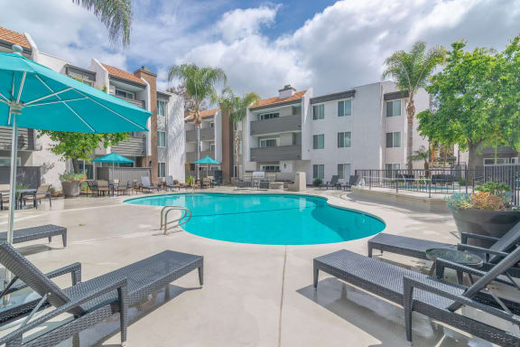 our apartments have a large swimming pool and lounge areas with umbrellas at City View Apartments at Warner Center, Woodland Hills, 91367
