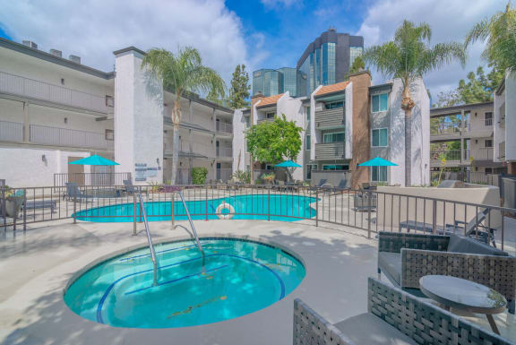 a swimming pool at a hotel with palm trees at City View Apartments at Warner Center, Woodland Hills