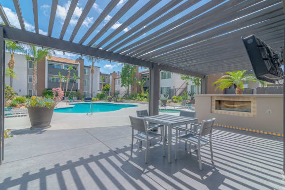 a patio with a table and chairs next to a pool at City View Apartments at Warner Center, Woodland Hills, 91367