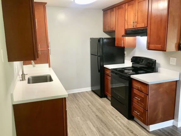a kitchen with black appliances and wooden cabinets at Element LLC, Sunnyvale, CA