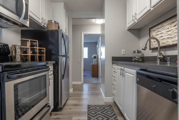 a kitchen with black appliances and white cabinets at Sunnyvale Crossings Apartments, LLC, Sunnyvale, CA 94087