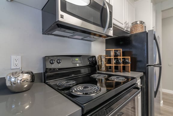a kitchen with a stove and a microwave at Sunnyvale Crossings Apartments, LLC, Sunnyvale, CA