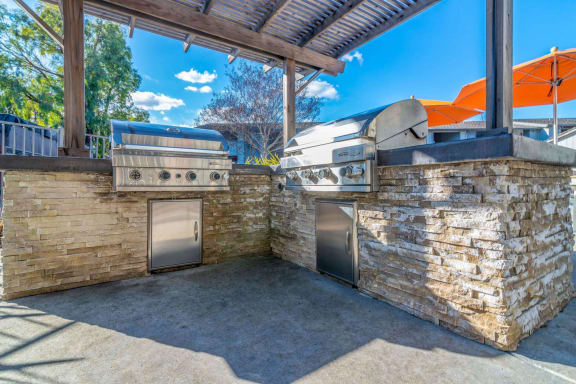 the outdoor kitchen has a grill and two bbqs at Sunnyvale Crossings Apartments, LLC, Sunnyvale