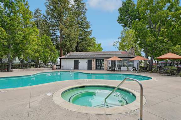 A small pool with a hot tub in the middle of it.