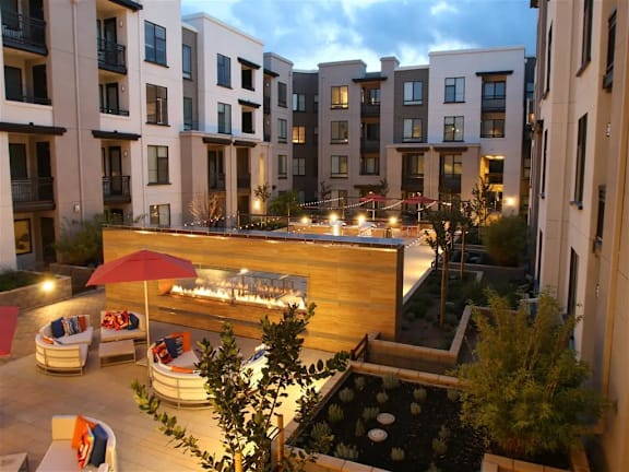 A patio with a table and chairs is surrounded by apartment buildings.at Catalyst Mountain View, California