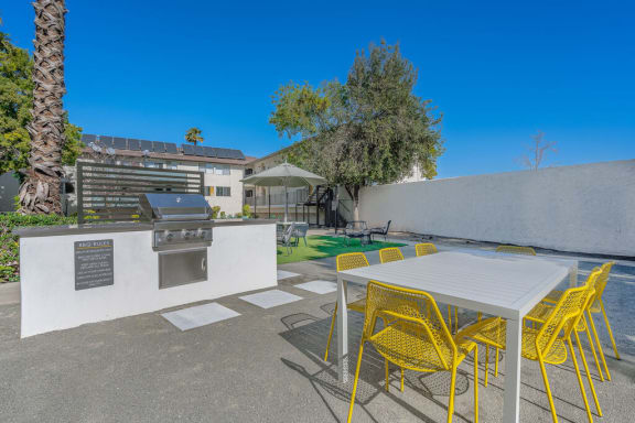 a patio with a table and chairs and a barbecue grill at The Hills Apartments at Thousand Oaks, California, 91360