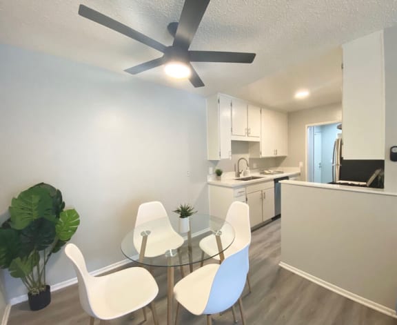a dining room with a glass table and chairs at The Hills Apartments at Thousand Oaks, Thousand Oaks California