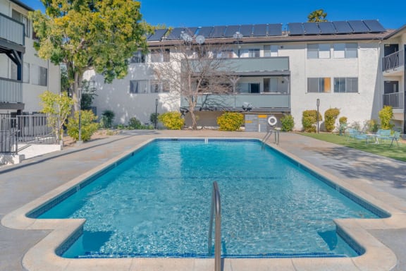 a swimming pool in front of an apartment building at The Hills Apartments at Thousand Oaks, Thousand Oaks, CA 91360