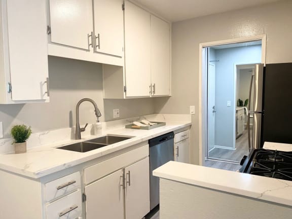 a kitchen with white cabinets and a sink at The Hills Apartments at Thousand Oaks, Thousand Oaks