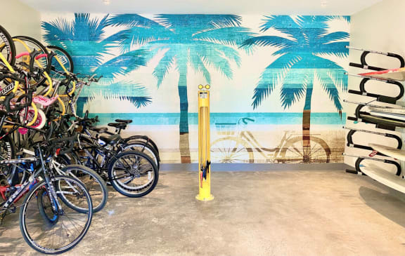 a group of bikes parked in front of a wall mural of a beach with palm at La Jolla Blue, San Diego, 92122