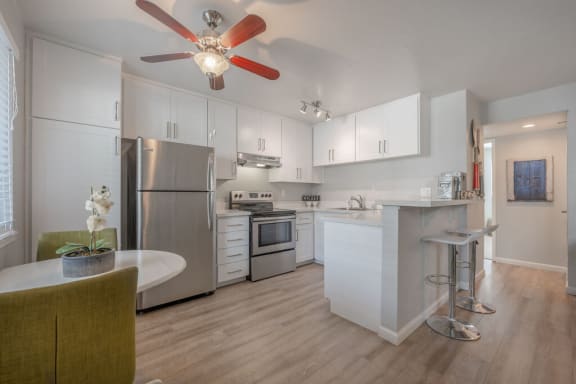 a kitchen with white cabinets and a ceiling fan at Napa Green Apartments LLC, Napa, 94559
