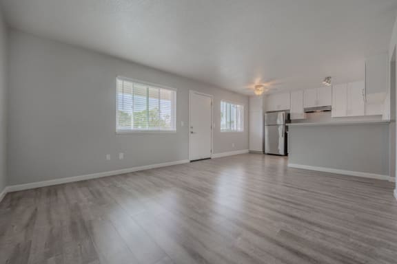 the living room and kitchen of an empty house with wood floors at Napa Green Apartments LLC, Napa