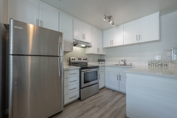 a white kitchen with stainless steel appliances and white cabinets at Napa Green Apartments LLC, California, 94559
