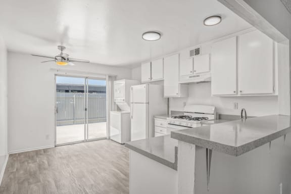 a white kitchen with a door to a patio at Ocean Villas, Oxnard