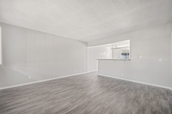 the living room and kitchen of an empty apartment at Ocean Villas, California