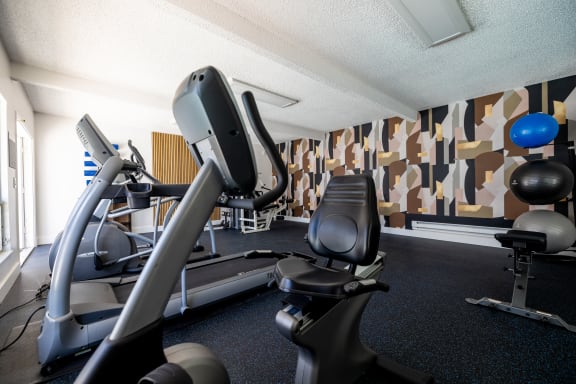 a gym with cardio equipment in a hotel gym room at Campbell West Apartments, California