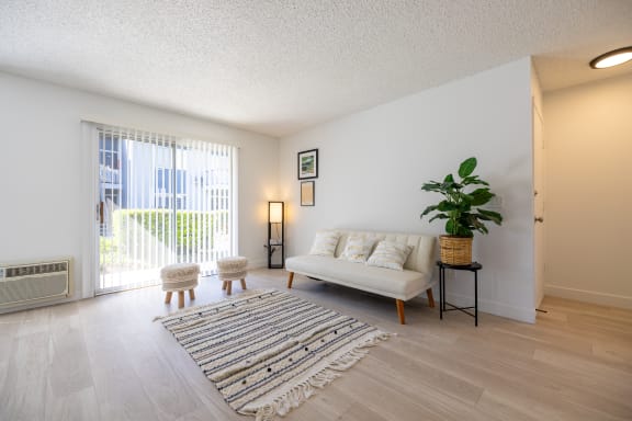 a living room with a couch and a rug at Campbell West Apartments, California