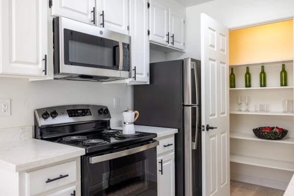 a kitchen with white cabinets and black appliances and a black refrigerator at Campbell West Apartments, Campbell, CA 95008