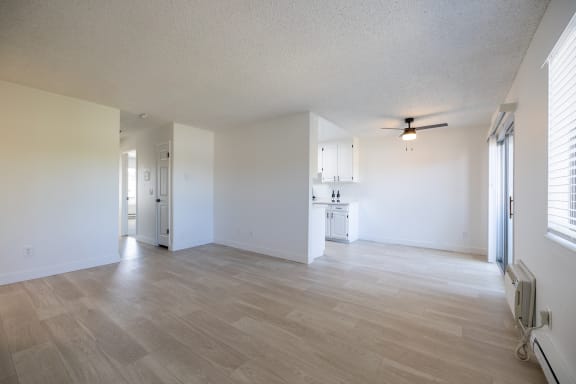 an empty living room and kitchen with a ceiling fan at Campbell West Apartments, Campbell, California