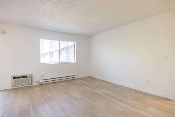 the living room of an apartment with wood flooring and a window at Campbell West Apartments, Campbell, California