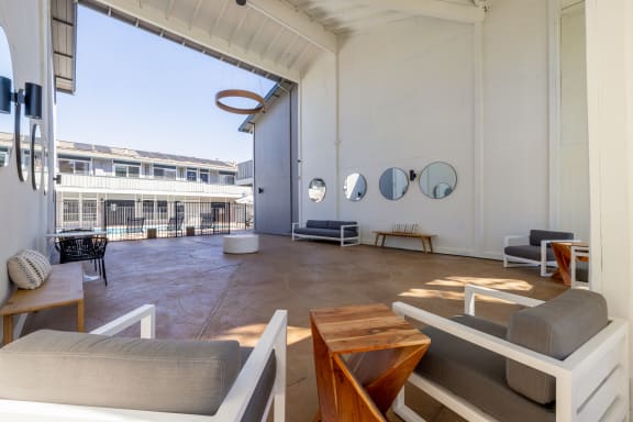 a living room with couches and tables and a large window at Campbell West Apartments, Campbell, CA
