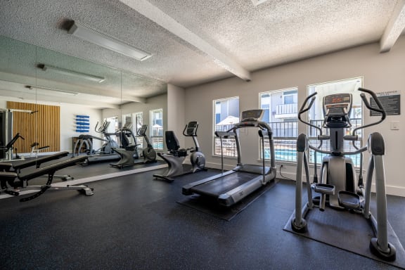 a gym with cardio machines and weights on the floor at Campbell West Apartments, Campbell