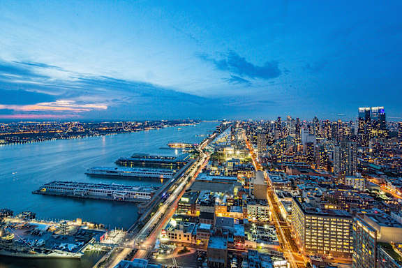 A cityscape at dusk with a bridge in the foreground at SKY Apartments, New York, NY