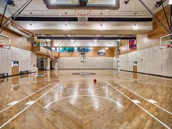a basketball court in the middle of a gym with a ball on it at SKY Apartments, New York, NY, 10036