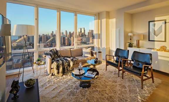 the living room of an apartment with a view of the city at SKY Apartments, New York, 10036