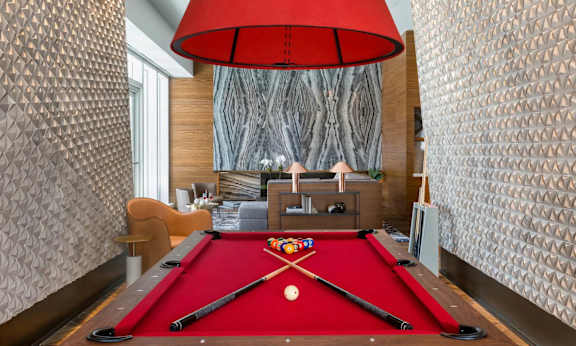 a pool table in a living room with a red pool at SKY Apartments, New York