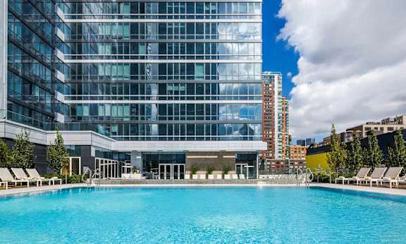 a swimming pool in front of a tall building at SKY Apartments, New York, 10036