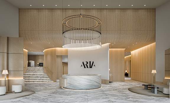 Aria hotel lobby with a large circular chandelier hanging from the ceiling.