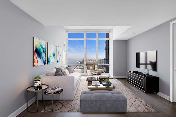 A modern living room with a large window and a grey sofa at SKY Apartments, New York, NY