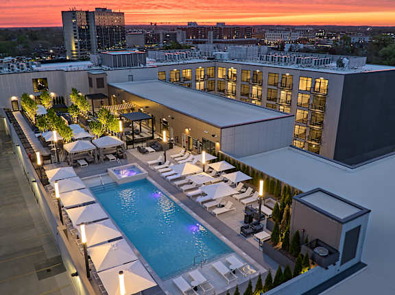A rooftop pool area with lounge chairs and umbrellas.