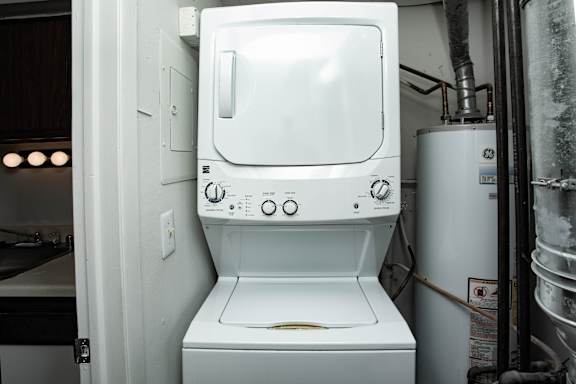 A white washing machine in a small room.