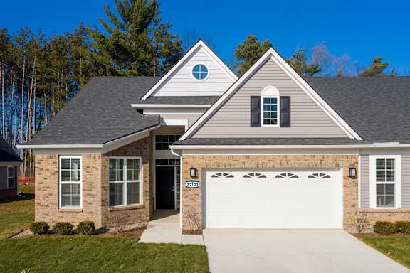 A two-story house with a garage and a driveway.