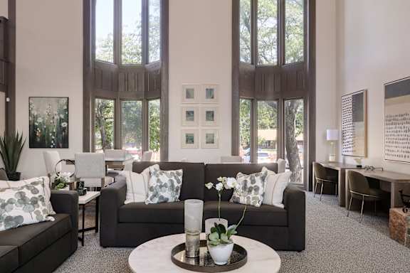 A living room with a couch, a coffee table, and a painting on the wall.