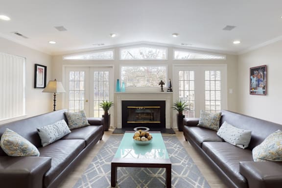 a living room with couches and a coffee table in front of a fireplace
