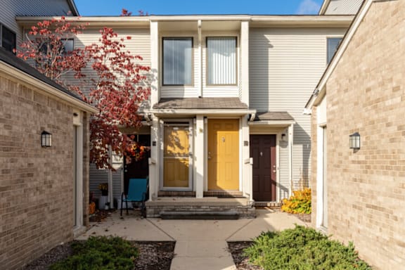 the front of a house with a yellow door