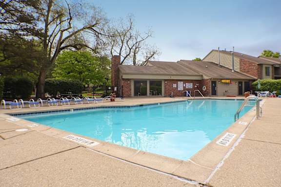 A large outdoor swimming pool with a building in the background.