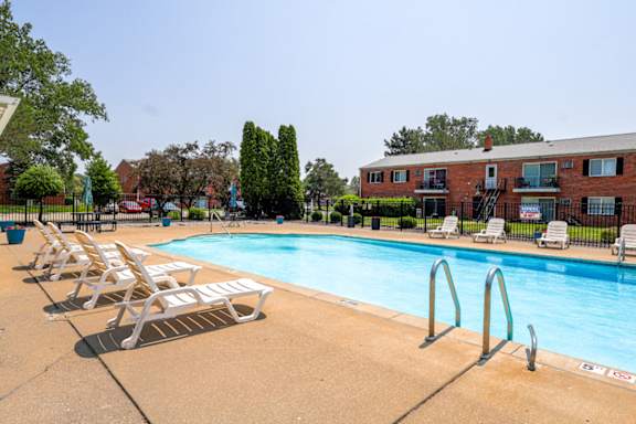 A pool with sundeck chairs surrounding it
