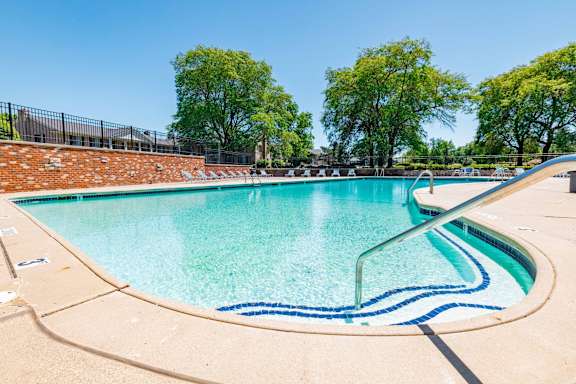 A large outdoor swimming pool with a blue line in the middle.