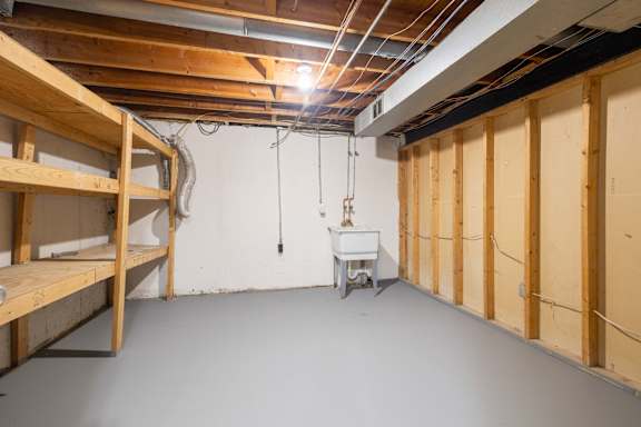 A room under construction with exposed ceiling beams and a workbench.