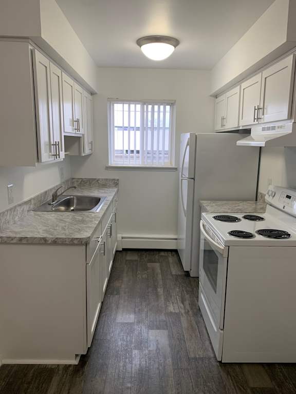A kitchen with white appliances and cabinets.