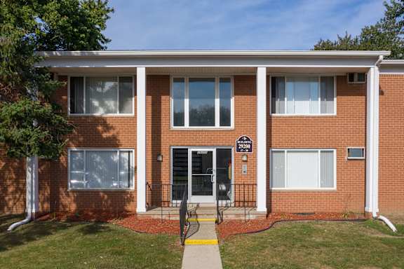 A red brick building with a black gate in front.