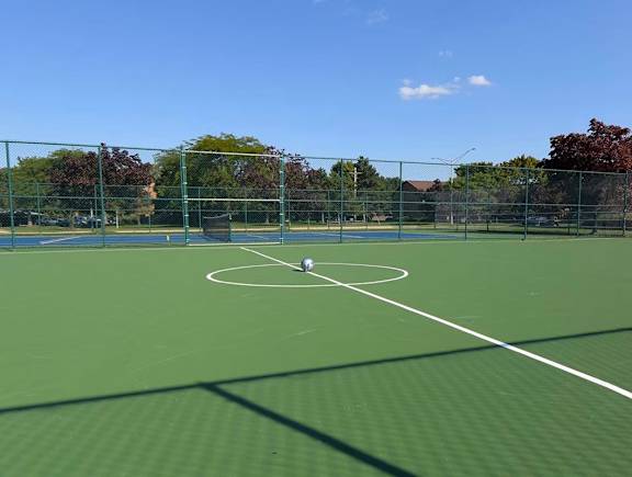 A tennis court with a net and a player in the middle.