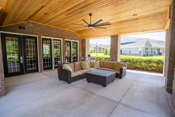 A patio with a couch and a fan.