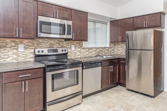 a kitchen with stainless steel appliances and wooden cabinets